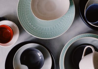 A stylish arrangement of various ceramic dishware in a top view flat lay composition.