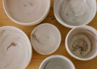 Top view of a collection of marble-textured ceramic bowls on a wooden surface.